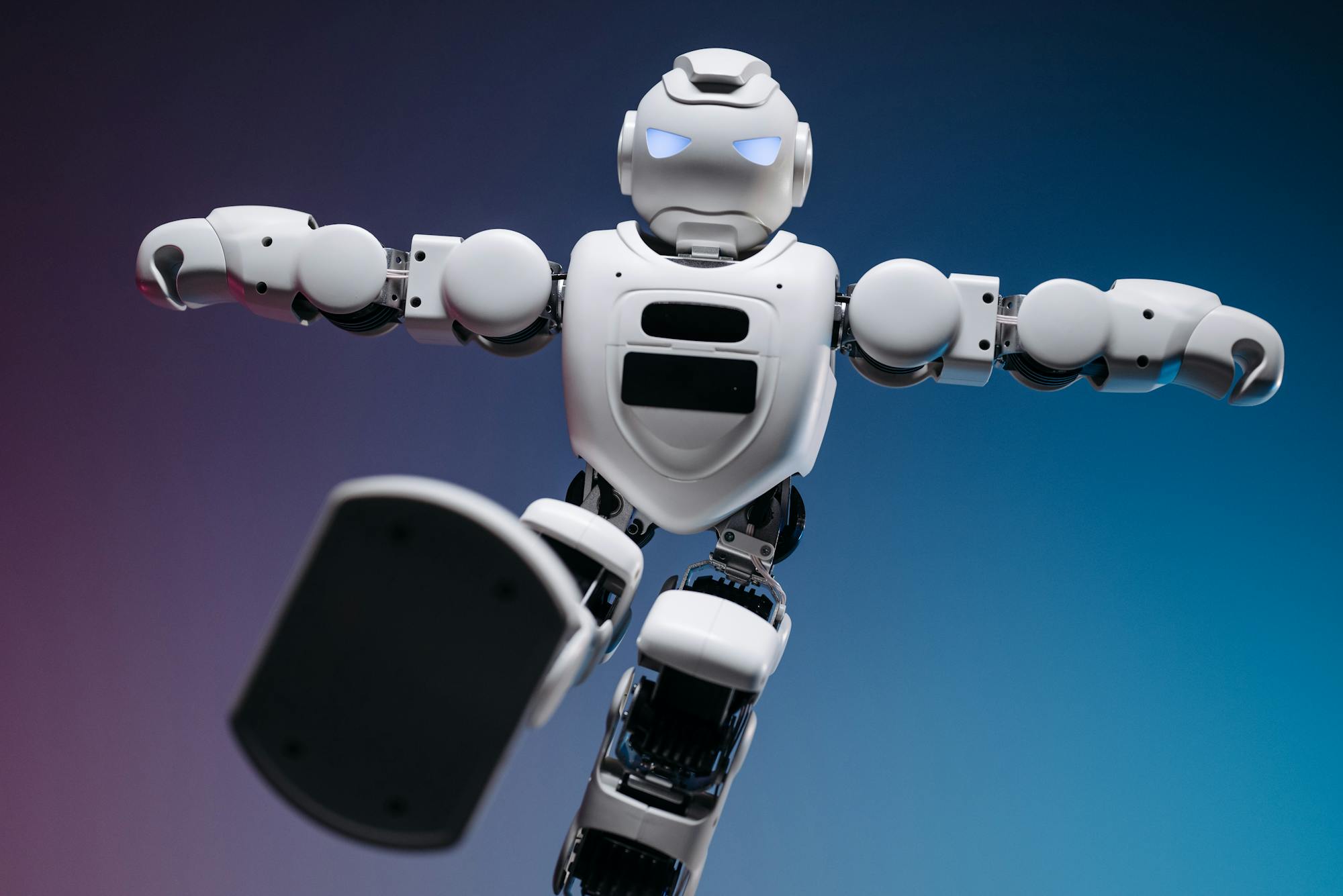 White humanoid robot on a blue and pink gradient background - smart automation concept